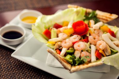 Beyaz tabakta soslu deniz ürünleri salatası..