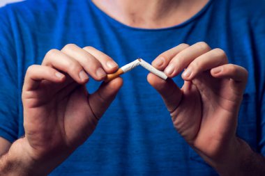 Sigara içmeyi bırak. Ellerinde kırık sigara. Kötü alışkanlığı, sağlık hizmetlerini ve insanların konseptini bırak. Sigara içme..