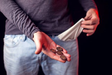 Adamın elinde kotunun ve sikkelerinin boş cebi var. Yoksulluk, mali sorunlar kavramı