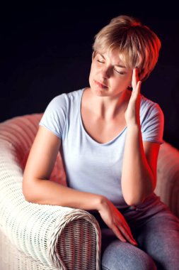 Kadın siyah arka planda şiddetli bir baş ağrısı hisseder. Halk, sağlık ve tıp konsepti