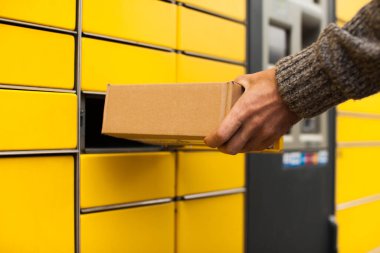 Sarı self-servis terminal makinesi. Adam bir paket alır