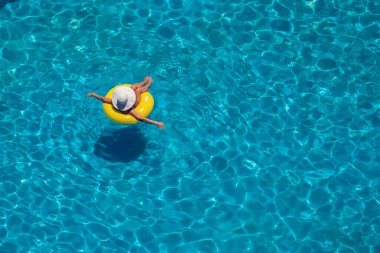 Kadın havuzda şişme dairede yüzüyor. Yukarı bak. Yaz ve tatil konsepti