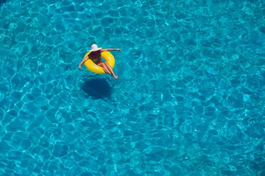 Kadın havuzda şişme dairede yüzüyor. Yukarı bak. Yaz ve tatil konsepti