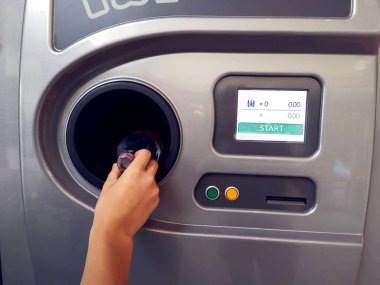 Adam şişeleri ve kutuları geri dönüşümlü satış makinesinde geri getiriyor. Çevre koruma kavramı