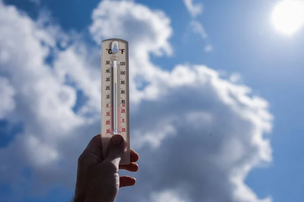 Mens Houdt Thermometer Hand Aan Hemel Met Wolkenachtergrond Weersconcept — Stockfoto