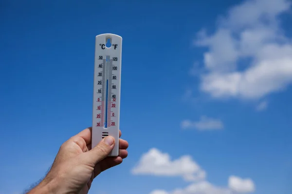 Mens Houdt Thermometer Hand Aan Hemel Met Wolkenachtergrond Weersconcept — Stockfoto