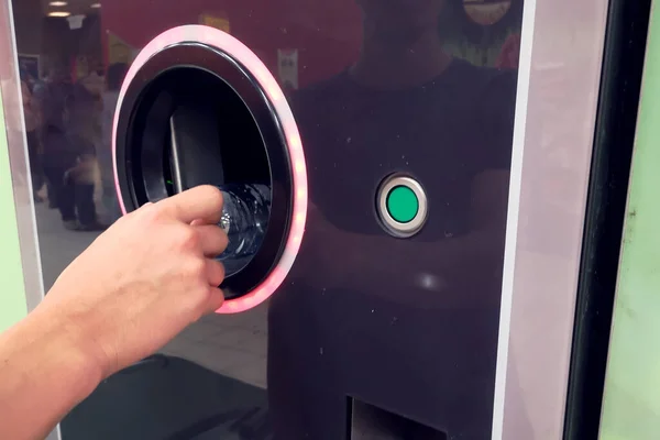 Shoppers return their bottles and cans of reusable packagings in a reverse vending machine