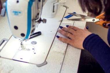 Bir terzi dikiş makinesiyle çalışır. Giyinme konsepti üretimi