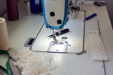 Ekipmanlı bir dikiş makinesi. Giyinme ve moda üretimi