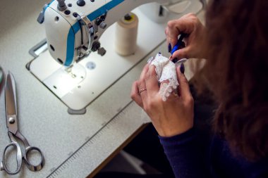 Bir terzi dikiş makinesiyle çalışır. Giyinme konsepti üretimi