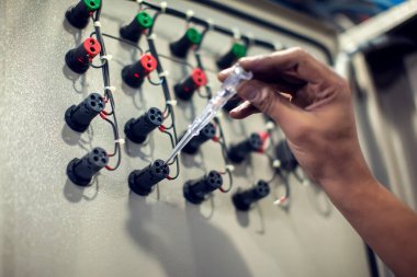 Erkek elektrikçinin sigorta kutusunu çoklu metre sondayla incelemesi