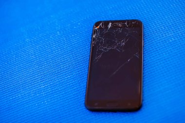 Mavi arkaplanda bozuk ekranı olan mobil akıllı telefon.