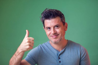 Gülümseyen mutlu adam baş parmağını gösteriyor. İnsanlar ve duygular.
