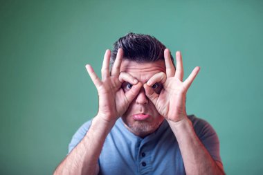 Genç adam baykuş işaretini parmaklarıyla gösteriyor. Suratını ekşitiyorsun. Keyfin yerinde olsun. İnsanlar, duygular ve yaşam tarzı