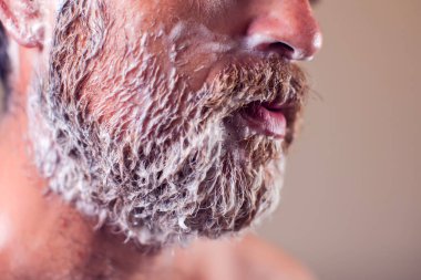 Tıraş köpüğüyle kaplı sakallı bir adamın portresi. İnsanlar ve güzellik konsepti