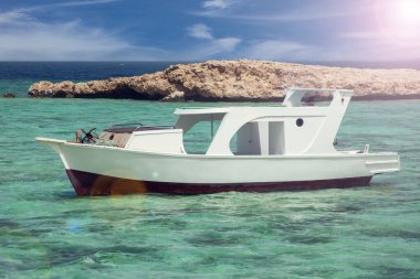 Kayalık adalı Mısır plajı ve Kızıl Deniz 'de beyaz tekne.