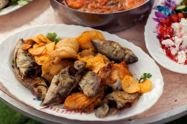 Masadaki tabakta farklı türde deniz yemekleri var.