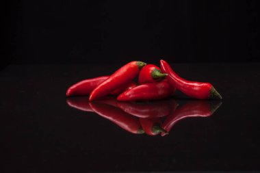 Siyah ayna arka planında kırmızı biber. Taze ve organik gıda konsepti