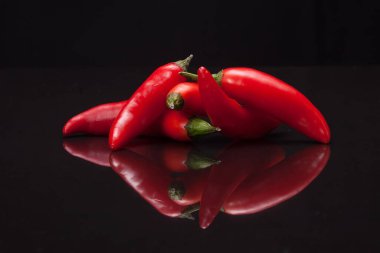 Siyah ayna arka planında kırmızı biber. Taze ve organik gıda konsepti