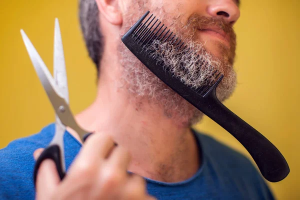 Man Met Baard Schaar Haarborstel Een Gele Achtergrond Mensen Levensstijl — Stockfoto