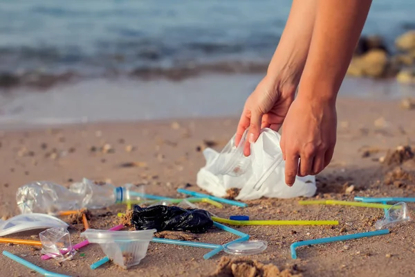 手工操作的女人在海滩捡塑料瓶清洁 环境污染概念 — 图库照片