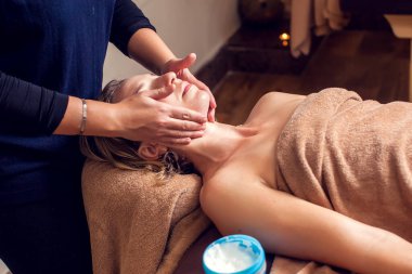 Spa, güzellik, insanlar ve vücut bakımı - güzellik salonunda yüz bakımı alan güzel bir kadın