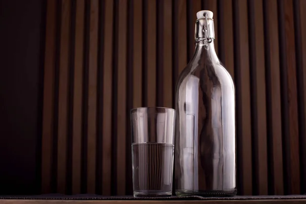 Tom Flaska Och Glas Med Vatten Över Trä Bakgrund — Stockfoto