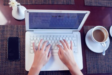 İnsanlar, teknoloji, iletişim ve eğlence kavramı. İnternette dizüstü bilgisayar kullanan, sosyal ağlar üzerinden haber kaynaklarını kontrol eden, öğle yemeği sırasında arkadaşlarıyla mesajlaşan bir kadın.