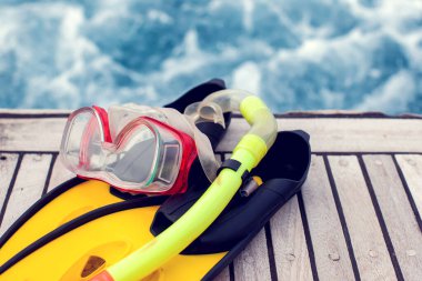 Yaz konsepti. Deniz manzaralı. Dalış maskesi ve paletler tekneye biner..