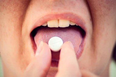 Ağzını aç ve dilinde ilaç hapını tut. İlaç alan bir kadın. Sağlık hizmetleri kavramı