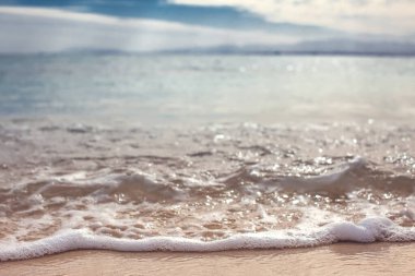 Kumlu sahilde yumuşak bir mavi okyanus dalgası. Geçmişi. Doğa konsepti