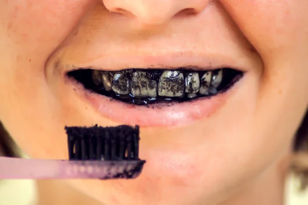 Young Woman Brushing Her Teeth Black Tooth Paste Active Charcoal - Stock-foto