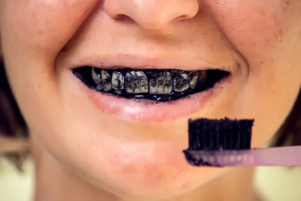 Young Woman Brushing Her Teeth Black Tooth Paste Active Charcoal - Stock-foto