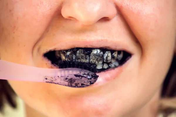 Young Woman Brushing Her Teeth Black Tooth Paste Active Charcoal - Stock-foto