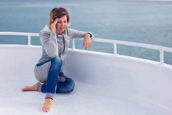 Deniz tutması geçiren turist kadın baş ağrısıyla deniz tutması geçiriyor. Seyahat ya da hastalık korkusu..