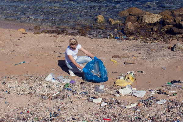 Kobieta Wolontariuszka Białej Koszulce Niebieską Torbą Zbierająca Śmieci Plaży Koncepcja — Zdjęcie stockowe