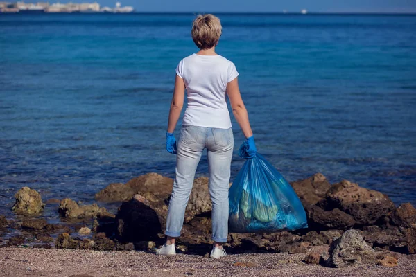 Woman Volunteer White Shirt Big Blue Bag Collecting Garbage Beach — Stock Fotó