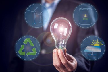 Businessman in suit holding in hands bulb with virtual sign of alternative energy. People and environmental protection concept