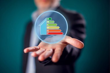 Businessman in suit showing open hand with virtual sign of energy rating. Energy saving and environment ptotection concept