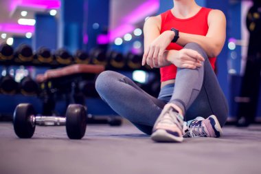 Woman in red top with short blond hair have a break in the gym. People, fitness and lifestyle concept