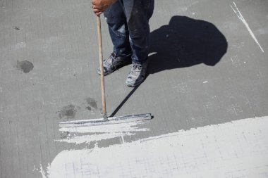 Havuz yenileme işi. Bir işçi havuzun dibine su geçirmez bir tabaka uyguluyor..