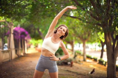 Dışarıda kadın eğitimi. Parkta esneme egzersizi. Spor ve sağlık hizmeti kavramı