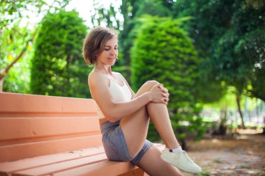 Bankta egzersiz yap. Parkta kadın eğitimi. Spor ve sağlık hizmeti kavramı 