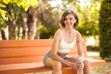 Parkta su içen sporcu kadın. Spor ve sağlık hizmeti kavramı