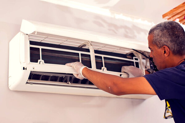 Man worker fixing air conditioning on the wall. Professional service