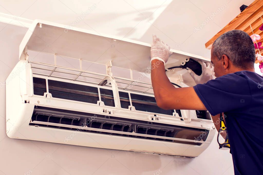 Man worker fixing air conditioning on the wall. Professional service