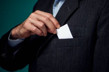 Takım elbiseli sakallı bir adamın portresi cebinden iş kartı alıyor.. 