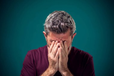 Kırmızı tişörtlü üzgün sakallı adamın portresi. İnsanlar ve duygular