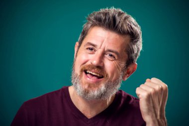 Kırmızı tişörtlü, sakallı, mutlu bir adamın portresi. İnsanlar ve duygular