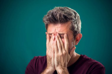 Kırmızı tişörtlü üzgün sakallı adamın portresi. İnsanlar ve duygular